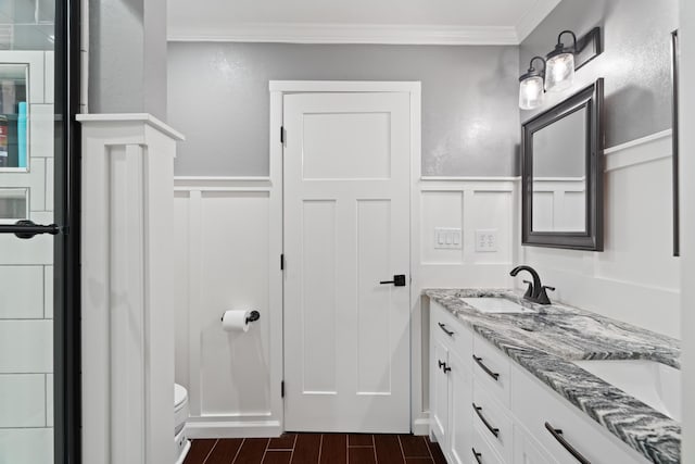 3689 Suzanne Way, Redding, CA 96002 - bathroom with crown molding, a decorative wall, a wainscoted wall, double vanity, and toilet