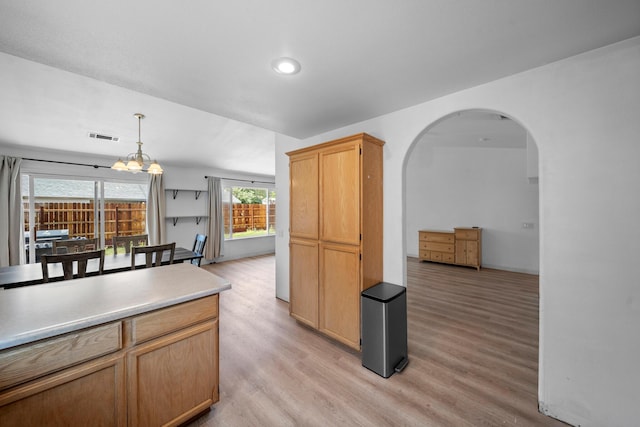 1706 Stanton Dr, Shasta Lake, CA 96019 - kitchen with arched walkways, light wood-style flooring, hanging light fixtures, a chandelier, and light countertops
