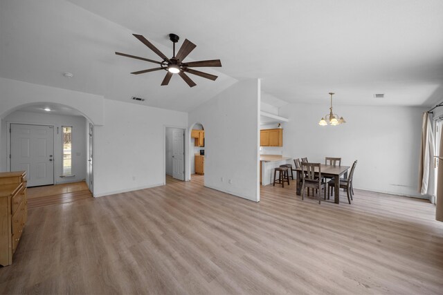 1706 Stanton Dr, Shasta Lake, CA 96019 - living room with arched walkways, vaulted ceiling, ceiling fan, a chandelier, and light wood finished floors