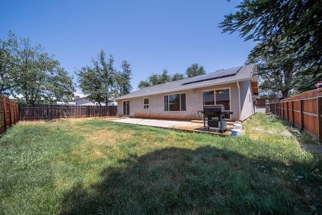 1706 Stanton Dr, Shasta Lake, CA 96019 - rear view of house with a fenced backyard, roof mounted solar panels, stucco siding, and a patio