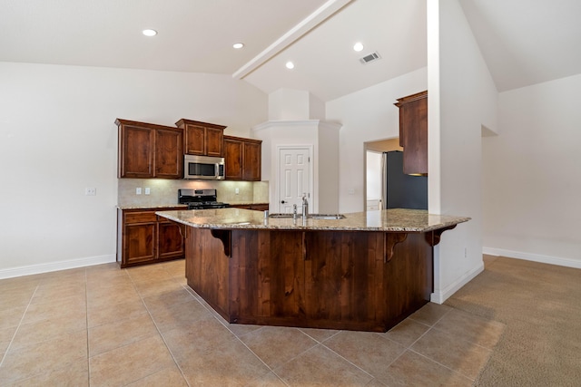6552 Capitola Pl, Redding, CA 96001 - kitchen featuring stainless steel appliances, high vaulted ceiling, light stone countertops, a kitchen bar, and tasteful backsplash