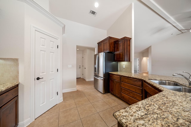 6552 Capitola Pl, Redding, CA 96001 - kitchen with stainless steel refrigerator with ice dispenser, a sink, lofted ceiling, light tile patterned floors, and light stone counters