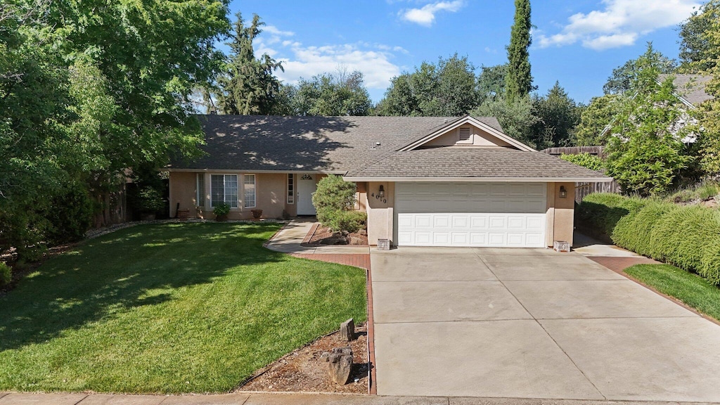 4010 Cambria Dr, Redding, CA 96002 - ranch-style home featuring a front yard, driveway, stucco siding, a garage, and roof with shingles