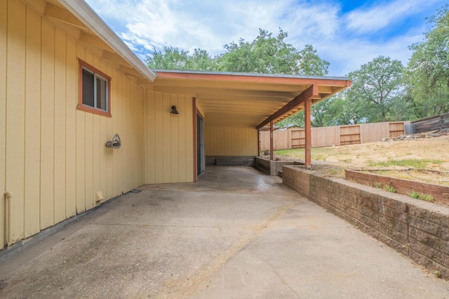 view of car parking featuring an attached carport and fence