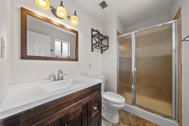 bathroom with a shower stall, toilet, and vanity