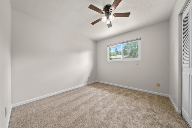 unfurnished bedroom with carpet floors, baseboards, a closet, and ceiling fan