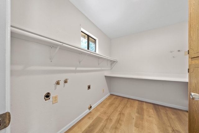 clothes washing area with hookup for an electric dryer, light wood finished floors, baseboards, and gas dryer hookup