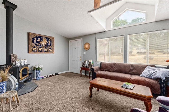 16605 Lassen Ave, Anderson, CA 96007 - living room with vaulted ceiling, a wood stove, and carpet floors