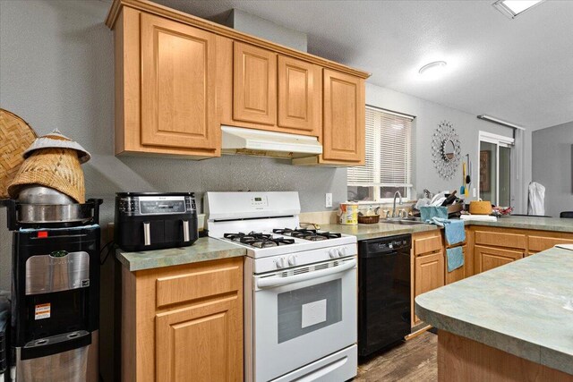 16605 Lassen Ave, Anderson, CA 96007 - kitchen with white gas stove, dishwasher, under cabinet range hood, wood finished floors, and a sink