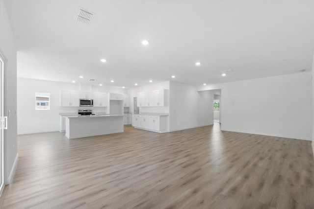 5555 Feathers Ave, Redding, CA 96002 - unfurnished living room with recessed lighting, light wood finished floors, and baseboards