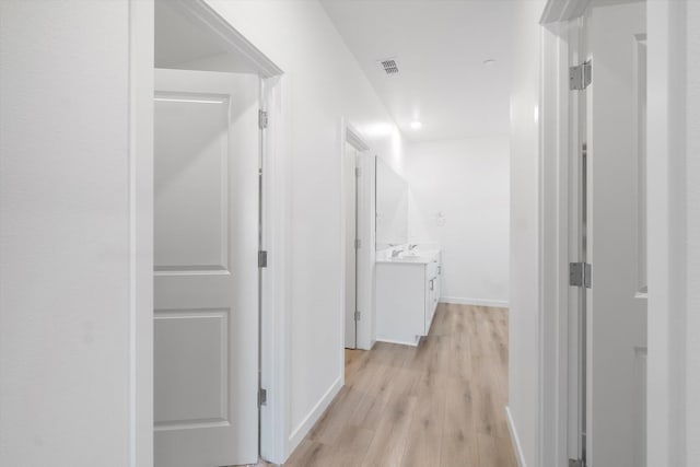 5555 Feathers Ave, Redding, CA 96002 - corridor featuring light wood-type flooring, baseboards, and a sink