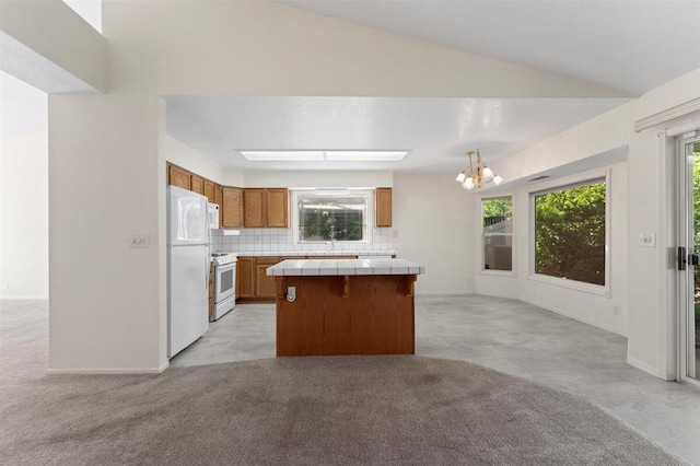 1366 Carla Cir, Redding, CA 96003 - kitchen featuring tile countertops, white appliances, brown cabinets, light carpet, and lofted ceiling