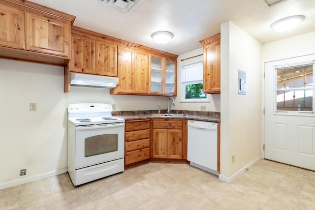 1556 Santa Fe Ave, Redding, CA 96003 - kitchen featuring white appliances, under cabinet range hood, a sink, dark countertops, and baseboards
