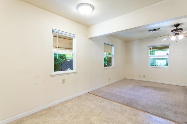 1556 Santa Fe Ave, Redding, CA 96003 - empty room with healthy amount of natural light, a ceiling fan, baseboards, and light colored carpet