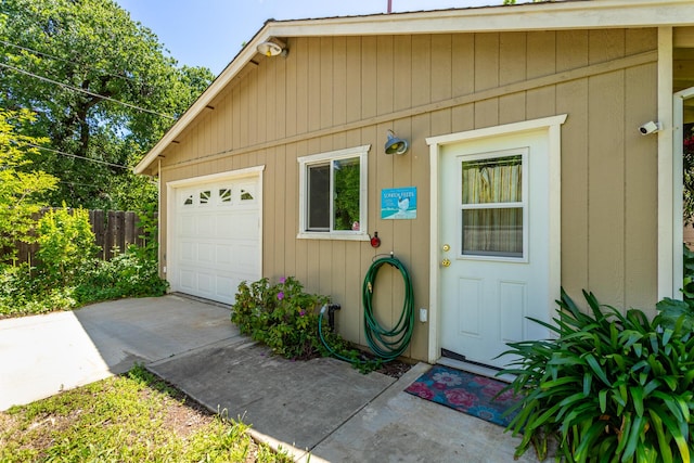 1556 Santa Fe Ave, Redding, CA 96003 - view of exterior entry featuring driveway, fence, an attached garage, and a surveillance system