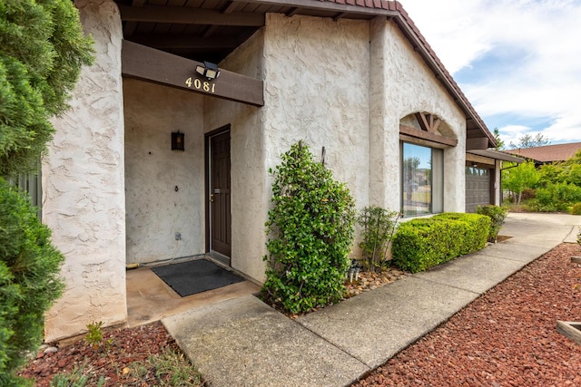 doorway to property with stucco siding and an attached garage