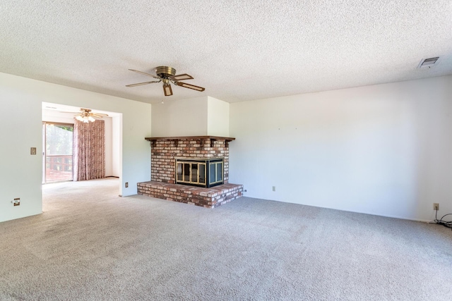 unfurnished living room with carpet, ceiling fan, a fireplace, and a textured ceiling