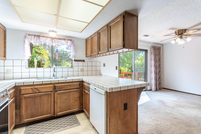 kitchen with dishwasher, healthy amount of natural light, a peninsula, and ceiling fan