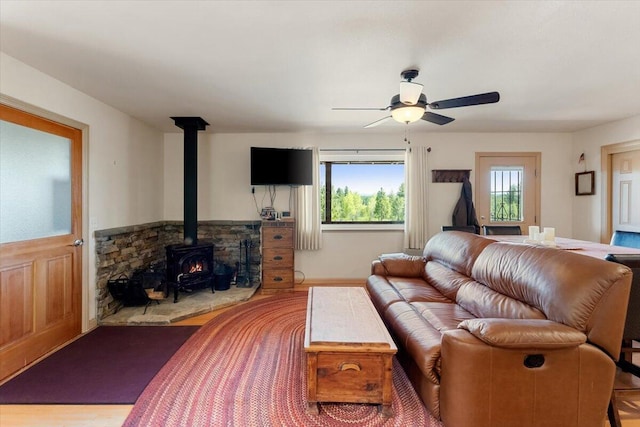 2125 Lava, Mccloud, CA 96057 - living area featuring a wood stove, healthy amount of natural light, ceiling fan, and wood finished floors