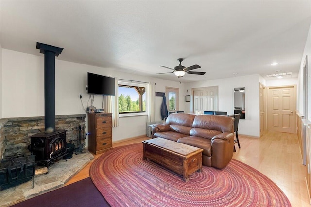 2125 Lava, Mccloud, CA 96057 - living area featuring a wood stove, light wood-style flooring, and ceiling fan