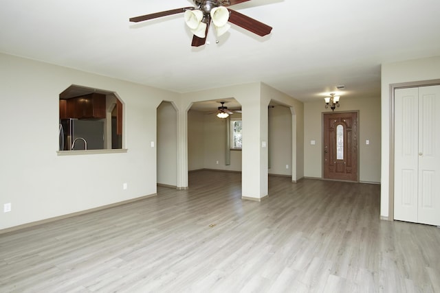 7289 Clarabelle Ln, Shingletown, CA 96088 - unfurnished living room featuring a ceiling fan, light wood finished floors, baseboards, and arched walkways