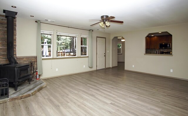 7289 Clarabelle Ln, Shingletown, CA 96088 - unfurnished living room with a wood stove, ceiling fan, wood finished floors, baseboards, and recessed lighting