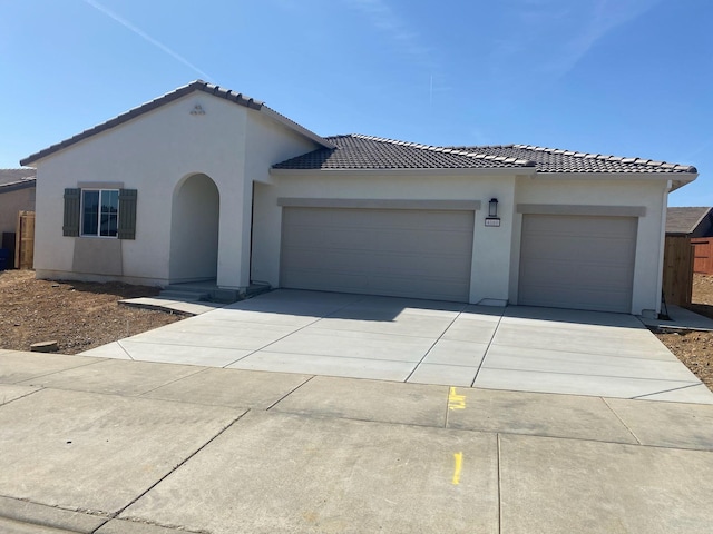 4181 Haleakala Ave, Redding, CA 96001 - mediterranean / spanish-style home with an attached garage, a tile roof, concrete driveway, and stucco siding
