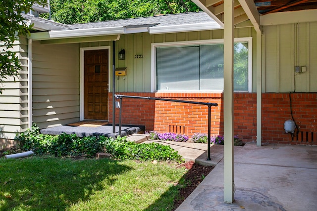 2722 Russell St, Redding, CA 96001 - doorway to property featuring board and batten siding, a shingled roof, and brick siding