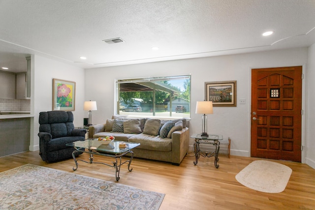 2722 Russell St, Redding, CA 96001 - living area featuring light wood-type flooring, baseboards, a textured ceiling, and recessed lighting