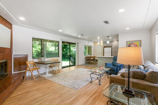 2722 Russell St, Redding, CA 96001 - living area featuring light wood finished floors, a fireplace, recessed lighting, and a textured ceiling