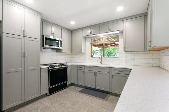 2722 Russell St, Redding, CA 96001 - kitchen featuring range with electric stovetop, stainless steel microwave, a sink, gray cabinets, and tasteful backsplash
