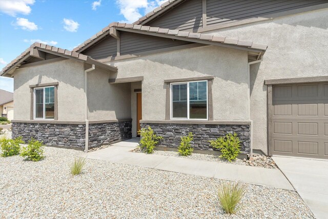903 Katmai Pl, Redding, CA 96001 - view of front of house featuring stucco siding, a garage, stone siding, and a tiled roof