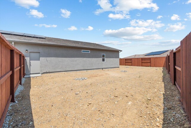 903 Katmai Pl, Redding, CA 96001 - rear view of property featuring a fenced backyard, roof mounted solar panels, and stucco siding