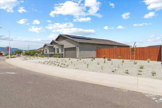 903 Katmai Pl, Redding, CA 96001 - view of front facade featuring solar panels, fence, an attached garage, and stucco siding