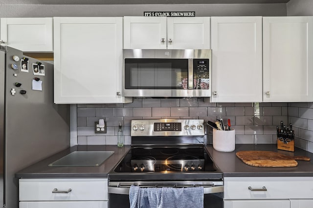 5801 Mountain View Dr, Redding, CA 96003 - kitchen with stainless steel appliances, dark countertops, white cabinets, and decorative backsplash