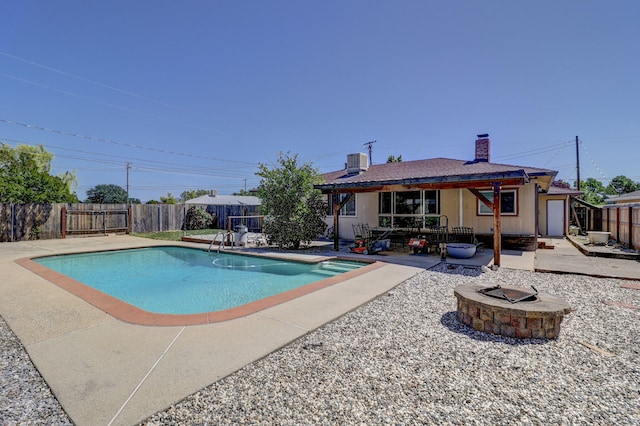 5801 Mountain View Dr, Redding, CA 96003 - view of swimming pool featuring an outdoor fire pit, a patio area, a fenced backyard, and central AC unit