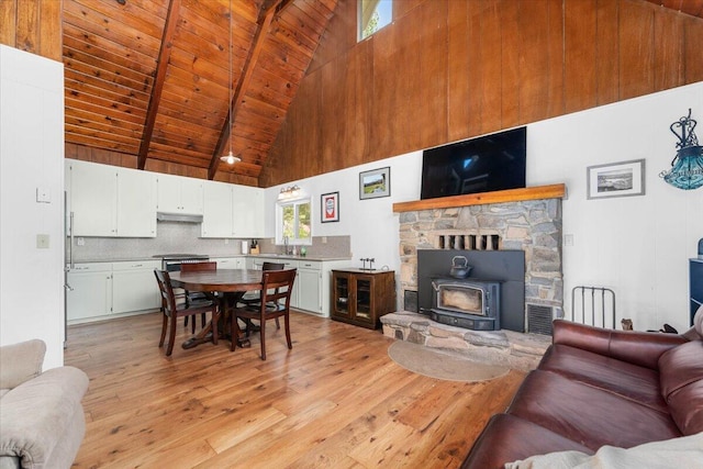 38290 Battle Creek Ave, Mineral, CA 96063 - dining room with high vaulted ceiling, a wood stove, light wood finished floors, and wooden ceiling with exposed beams