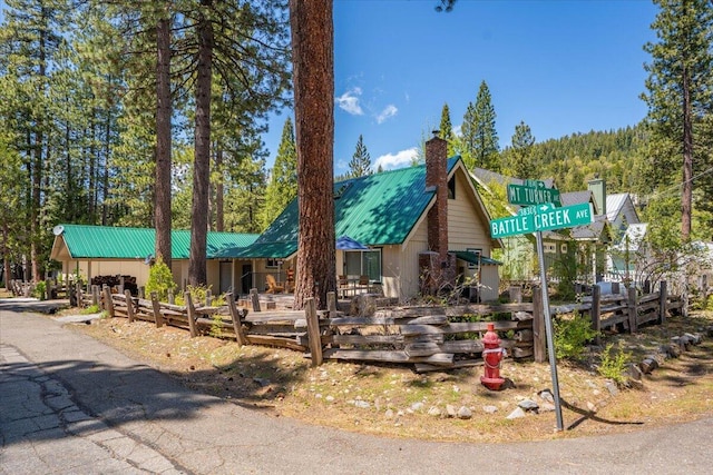 38290 Battle Creek Ave, Mineral, CA 96063 - view of front of home with metal roof, a wooded view, and a chimney