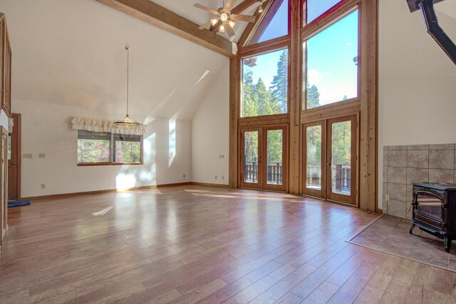 34836 Emigrant Trl, Shingletown, CA 96008 - unfurnished living room with high vaulted ceiling, a wood stove, beam ceiling, french doors, and a ceiling fan