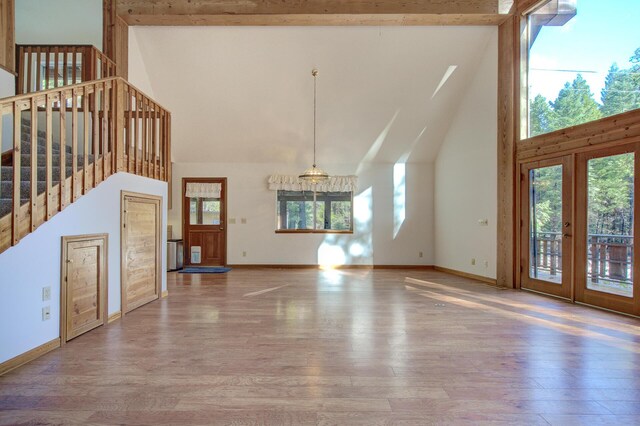 34836 Emigrant Trl, Shingletown, CA 96008 - unfurnished living room with high vaulted ceiling, plenty of natural light, stairway, wood finished floors, and beamed ceiling
