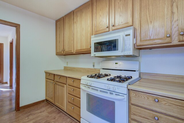 34836 Emigrant Trl, Shingletown, CA 96008 - kitchen with white appliances, light wood-style flooring, light countertops, baseboards, and light brown cabinets