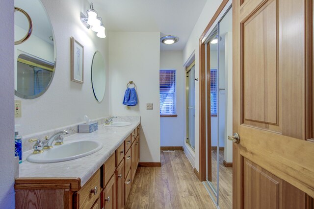 34836 Emigrant Trl, Shingletown, CA 96008 - bathroom with wood finished floors, a stall shower, double vanity, and baseboards