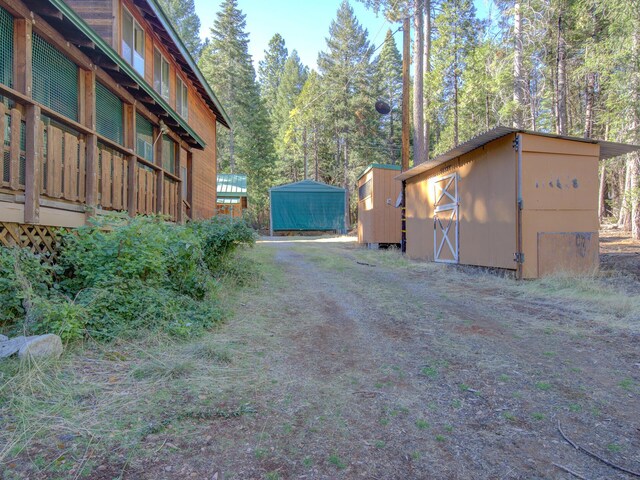 34836 Emigrant Trl, Shingletown, CA 96008 - view of yard with a shed, an outbuilding, a carport, and driveway