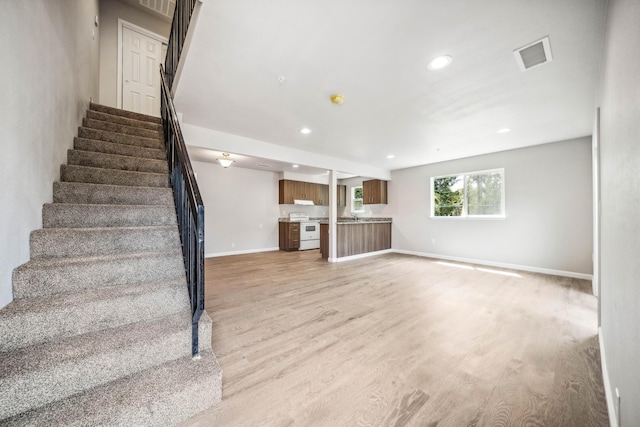 628 Hartnell Ave, Redding, CA 96002 - unfurnished living room with stairs, baseboards, light wood finished floors, and recessed lighting