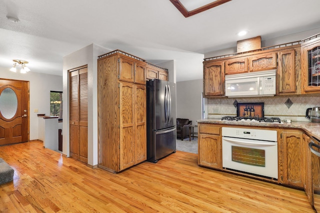 31272 Woodridge Dr, Shingletown, CA 96088 - kitchen featuring white appliances, light wood-style flooring, backsplash, brown cabinets, and recessed lighting