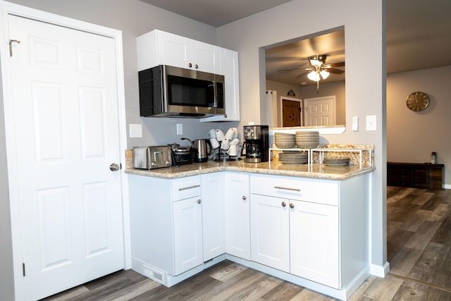 1018 Pineland Dr, Redding, CA 96002 - kitchen with stainless steel microwave, light wood-style floors, a ceiling fan, and light stone countertops