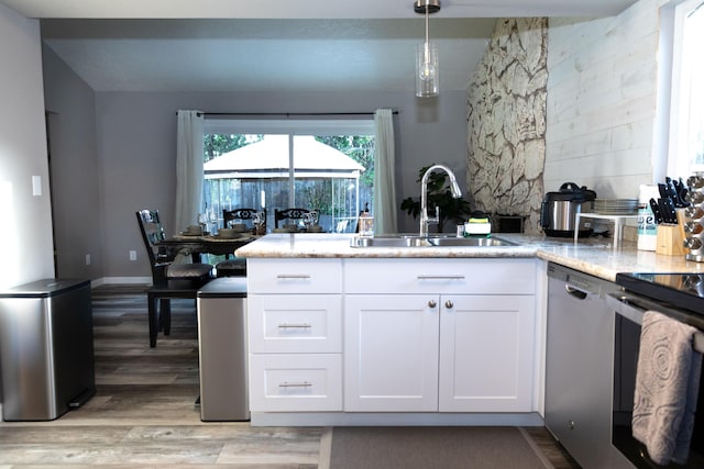 1018 Pineland Dr, Redding, CA 96002 - kitchen with a sink, dishwashing machine, a peninsula, white cabinetry, and light wood-style floors