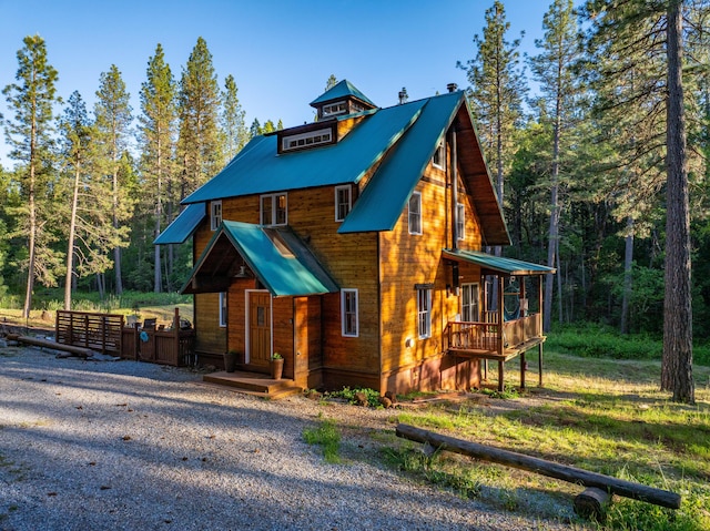 7704 Eastmoore Rd, Shingletown, CA 96088 - rustic home featuring metal roof, a view of trees, and a deck