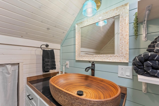 7704 Eastmoore Rd, Shingletown, CA 96088 - bathroom with lofted ceiling, a sink, wooden walls, and wooden ceiling