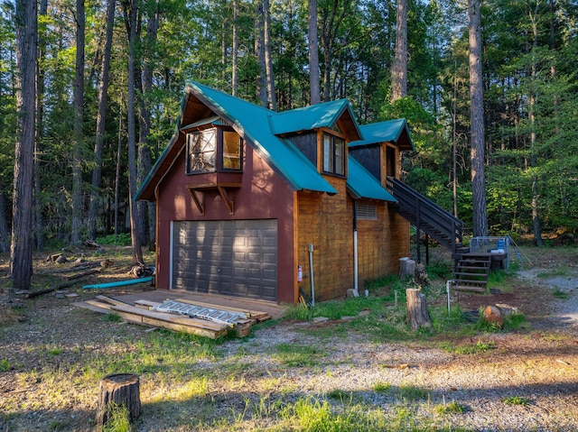 7704 Eastmoore Rd, Shingletown, CA 96088 - view of side of property featuring stairs, a garage, and a view of trees